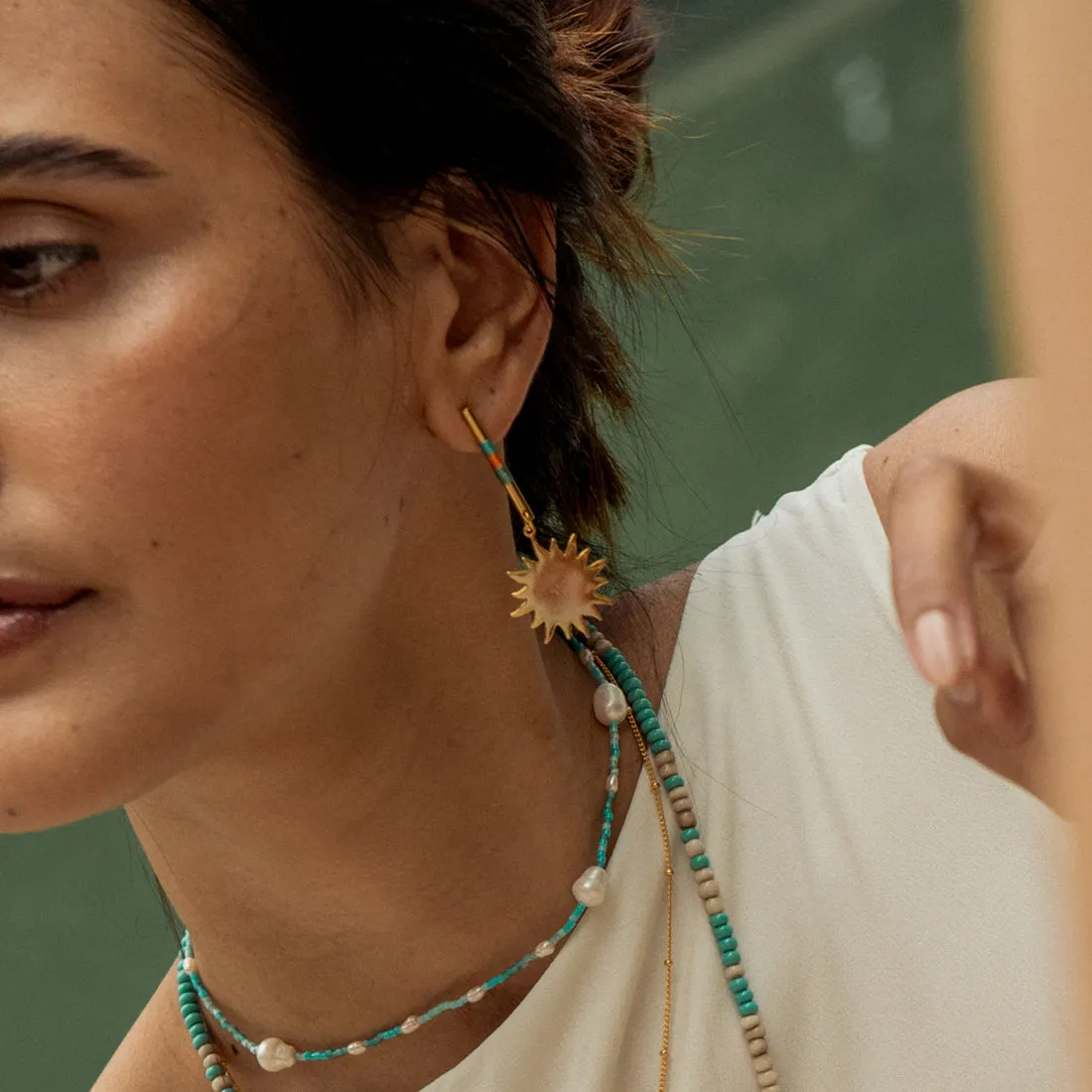 Bar earrings with woven threads and suspended sun charm