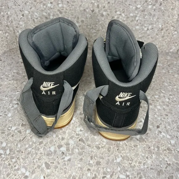 Nike Air Force 1 in Black Canvas. Gold Accents on laces.